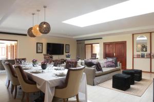 a dining room and living room with a table and a couch at The Finches Nest in Hammanskraal