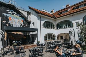 two women sitting at tables outside of a building at Layer Residences in Kranj