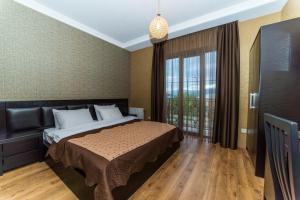 una camera da letto con un letto e una grande finestra di Hotel New Telavi a Telavi