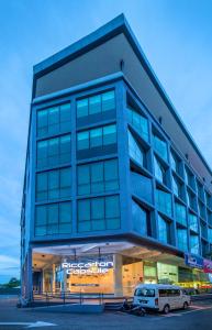 um edifício com um carro estacionado em frente em Riccarton Capsule Hotel em Kuala Lumpur