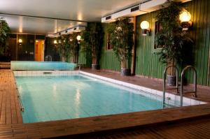 a large swimming pool in a building with plants at Hotell Kung Gösta in Mora