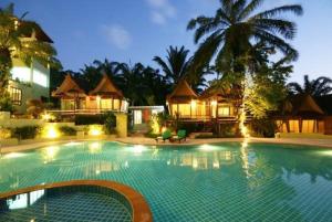 a swimming pool in front of a house at night at Palm Paradise Resort in Ao Nang Beach