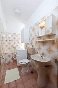 a bathroom with a toilet and a sink at Apartmani Denis Vela in Podgora +15 photos