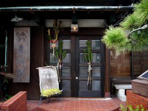 uma porta da frente de uma casa com vasos de plantas em Guest House Kamejikan em Kamakura