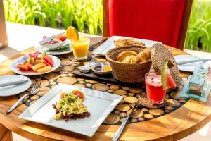 a table with plates of food and drinks on it at The Chandi Boutique Resort & Spa in Senggigi