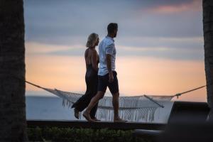 a man and a woman walking on a dock at The Chandi Boutique Resort & Spa in Senggigi