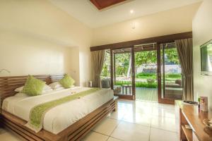 a bedroom with a large bed and a sliding glass door at The Chandi Boutique Resort & Spa in Senggigi