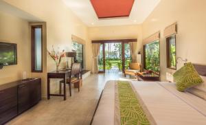 a bedroom with a bed and a desk in a room at The Chandi Boutique Resort & Spa in Senggigi