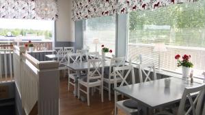 um restaurante com mesas brancas e cadeiras brancas e uma janela em Hotell Kung Gösta em Mora