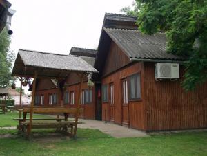 a wooden building with a picnic table next to it at Faház Motel in Abádszalók