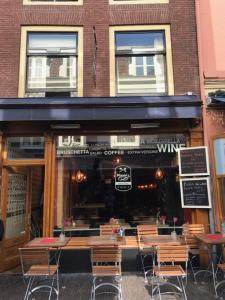 a restaurant with tables and chairs in front of a building at Maria's Suite in Utrecht