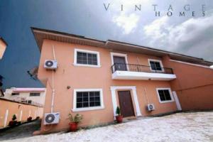 a large orange house with a balcony on it at Vintage Homes Lekki in Lagos