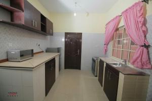 eine Küche mit einem Waschbecken und einem rosa Vorhang in der Unterkunft Vintage Homes Lekki in Lagos
