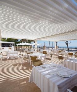 a restaurant with white tables and chairs under a white canopy at Hotel Casa Vilella 4* Sup in Sitges