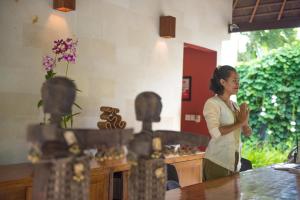 Una donna in piedi in una cucina con le mani di The Chandi Boutique Resort & Spa a Senggigi