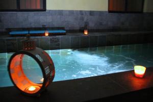 a swimming pool with two candles and a mirror at Chambre d'Hôtes La Grenade Bleue in Pons