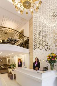 two women standing at a counter in a lobby at Luxury Old Quarter Hotel & Gym in Hanoi