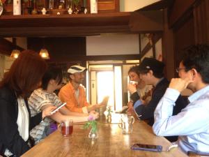 um grupo de pessoas sentadas à volta de uma mesa em Guest House Kamejikan em Kamakura