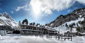 a large building with snow on it in the mountains at Hotel Hospital de Benasque in Benasque