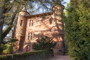 an old stone building with trees in front of it at Chateau de Canac in Rodez