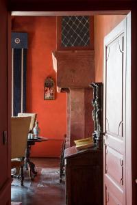 ロデーズにあるChateau de Canacのオレンジ色の壁の客室で、テーブルとテーブルが備わります。