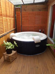 eine Whirlpool-Badewanne auf einer Holzterrasse in der Unterkunft la cariole in Saint-Pierre