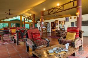 een woonkamer met stoelen en een salontafel bij Mbuzi Mawe Serena Camp in Serengeti