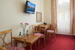 プラハにあるアンナ　ホテルのテーブルと椅子、壁にテレビが備わる客室です。