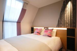 a bedroom with a white bed with two pillows at Kyoto Tower Hotel Annex in Kyoto +43 photos