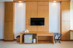 a living room with a tv and a wooden wall at Sann View Hotel in Thoeng