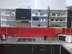 a kitchen with red cabinets and a counter top at Bienvenue chez vous in Kenitra