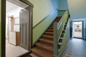 uma escadaria numa casa com paredes verdes e tectos azuis em Familienstudio 27 em Berlim
