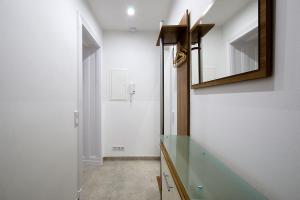 uma casa de banho com um balcão de vidro e um espelho em Familienstudio 27 em Berlim