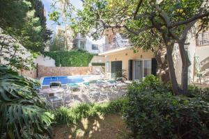 patio z krzesłami i basenem przed budynkiem w obiekcie Hostal Bonany w Palma de Mallorca