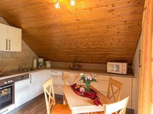 una cocina con una mesa con un jarrón de flores. en Stinneshof en Oberharmersbach