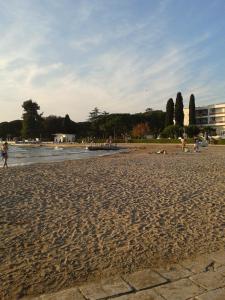 ein Sandstrand mit Menschen auf dem Wasser in der Unterkunft Ravkin Apartments in Zadar