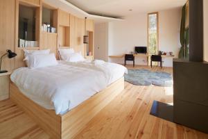 une chambre avec un grand lit blanc et un salon dans l'établissement Les Échasses Golf & Surf Eco Lodge, à Saubion