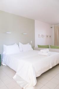 a white bedroom with two beds with towels on them at Apartments Balaska in Xiropigado