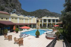 オルデニズにあるTokgoz Butik Hotel&Apartmentのリゾートで、プール、テーブル、椅子を提供しています。