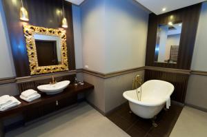 a bathroom with a tub and a toilet and a sink at Hotel Oriza in Gdów