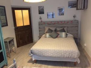 Schlafzimmer mit einem großen Bett mit einem Kopfteil aus Holz in der Unterkunft Gîte sur Loue in Ornans