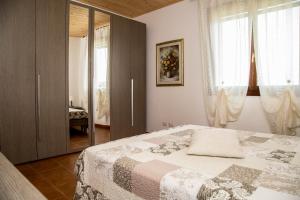 1 dormitorio con 1 cama y puerta de cristal en Villa Rosanna en Alguer