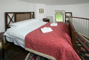 a bedroom with a large bed with two towels on it at Drum Gatelodge in Bushmills