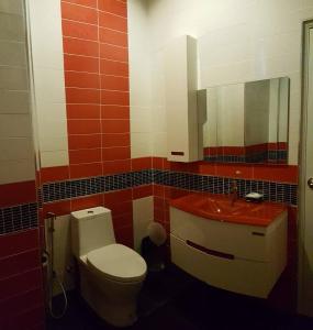Un baño con inodoro, lavabo y espejo. en Dusita Grand Resort, en Hat Yai
