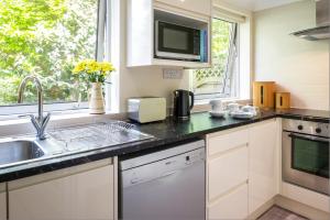 a kitchen with a sink and a microwave at Gwithian Holidays in Hayle