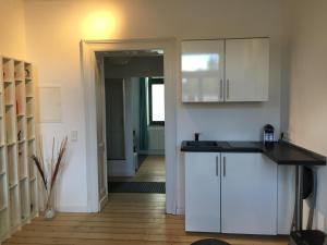 cocina con armarios blancos y encimera en Apartment KR18, en Ratingen