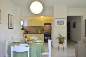 een keuken en eetkamer met een groene tafel en stoelen bij Apartments Lounger Crikvenica in Crikvenica