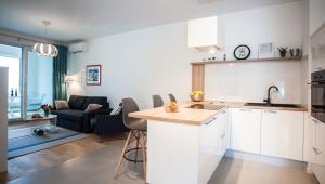 a kitchen with white cabinets and a living room at Apartment Morska vila in Split