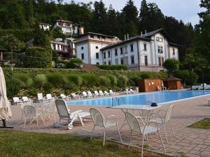 Eine Gruppe von Stühlen und Tischen neben einem Pool in der Unterkunft Anna in Oggebbio