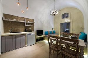 a kitchen and dining room with a table and chairs at Nefeli Homes in Imerovigli